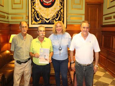 La alcaldesa presenta el cartel de TropiCaza junto con Antonio Escámez (izq) y los representantes del Club Deportivo de Caza Los Tablones